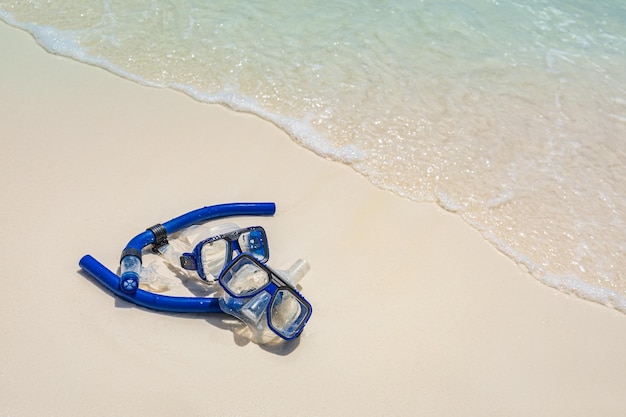 Cenário de praia de verão com googles de equipamento de snorkel na areia macia, aventura de liberdade de atividade recreativa