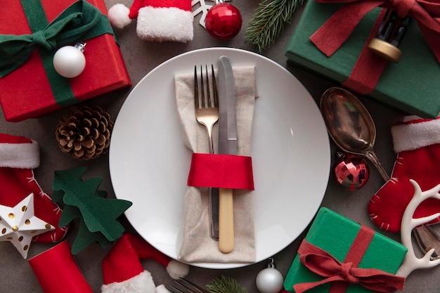 Cenário festivo de fundo de refeição de natal com prato e talheres cercado por decorações de...