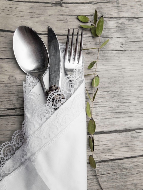 Cenário festivo para o jantar de natal Talheres vintage no guardanapo branco e cone de abeto no fundo de madeira velho