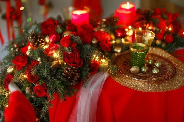 Foto cenário para velas vermelhas closeup de natal na mesa e grinaldas de natal