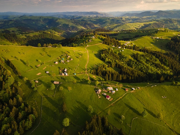 Cenário rural montanhoso em casas de campos de pôr do sol e árvores nos cárpatos da natureza montanhosa