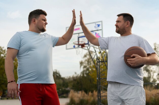 Foto cenas autênticas de homens de tamanho grande jogando basquete
