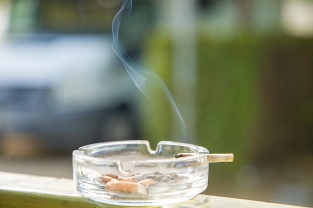 Un cenicero con un cigarrillo en él y un cigarro en él.