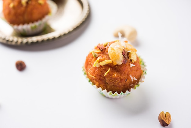 Cenoura Halwa Laddu ou bolinhos doces, servidos em um prato com coberturas de frutas secas. foco seletivo