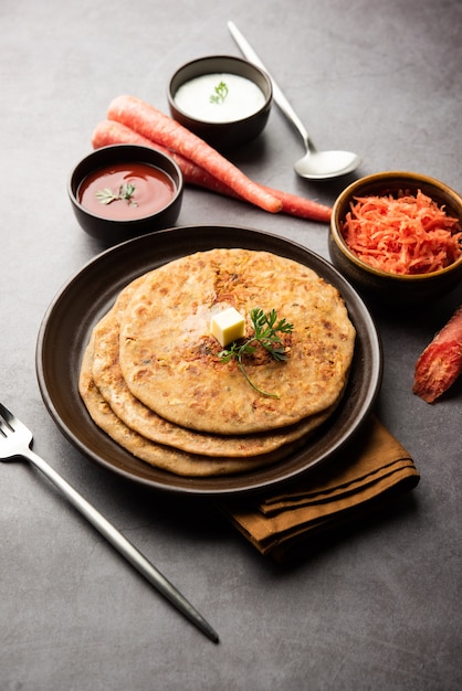 Cenoura ou gajar ka paratha é um prato de Punjabi que é um pão achatado sem fermento indiano feito com farinha de trigo integral e cenoura. Servido com ketchup e requeijão