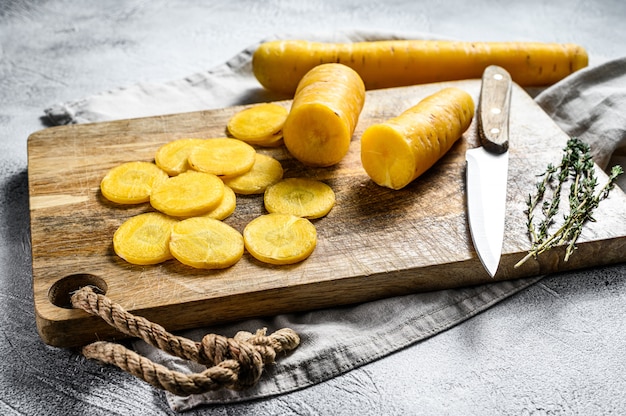 Cenouras amarelas frescas cortadas sem partes superiores, o conceito de cozinhar vegetais. superfície cinza. vista do topo