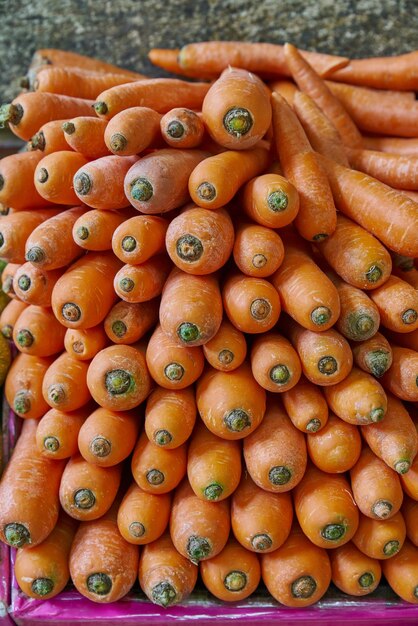 Cenouras empilhadas e classificadas colocadas em uma prateleira para venda em um mercado