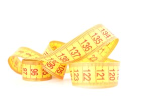 Centímetro de pornografia flexível amarelo para medições em um fundo branco