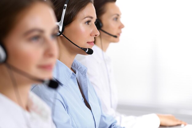 Central de atendimento. grupo de operadores no trabalho. concentre-se na bela mulher de negócios no fone de ouvido.