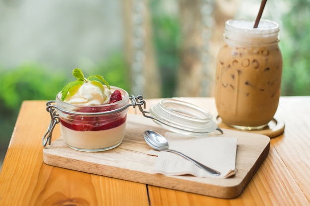 centrarse en el café con hielo con fondo de panacotta de fresa