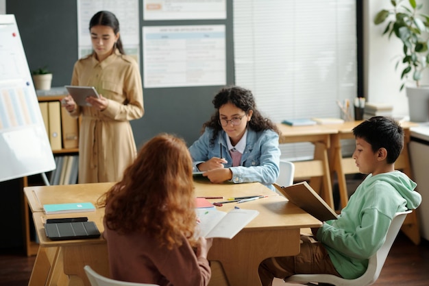 Centrarse en un grupo de escolares interculturales leyendo sus notas
