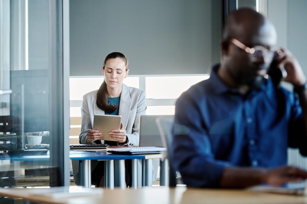 Centrarse en la joven empresaria o secretaria mirando la pantalla de la tableta