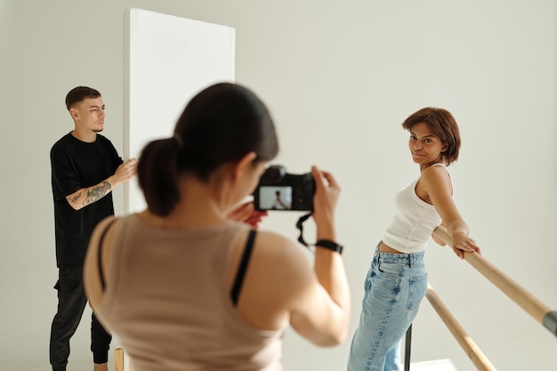 Centrarse en la joven modelo femenina posando para un fotógrafo profesional