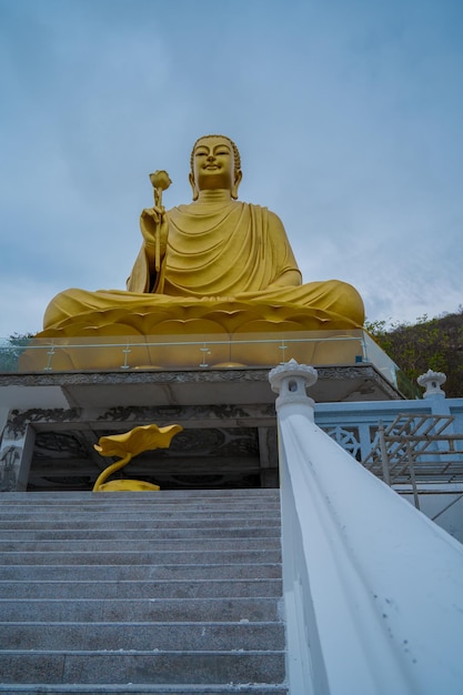 Centrarse en la mano de la estatua de Buda de oro sosteniendo el loto en el monasterio de Chon Khong