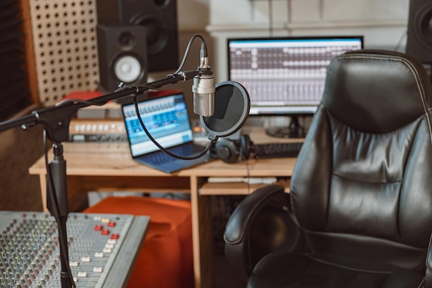 Centrarse en el micrófono profesional en el lugar de trabajo para la transmisión de sonido de espacio de ensayo de música