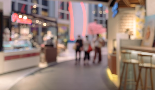 Centro comercial borroso abstracto con gente caminando de fondo