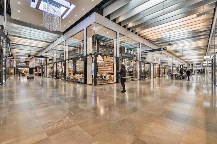 Un centro comercial con gente caminando y una tienda.