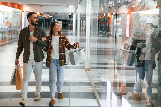 En el centro comercial con ropa Una pareja joven está en el supermercado juntos