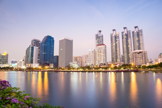 Centro da cidade de Bangkok e crepúsculo do parque público com a reflexão do horizonte na hora do Crepúsculo