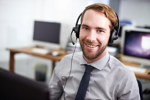 Centro de atendimento de retrato e homem com um sorriso telemarketing e atendimento ao cliente com um fone de ouvido Funcionário do sexo masculino e consultor feliz com fones de ouvido suporte técnico e comunicação com a empresa cm