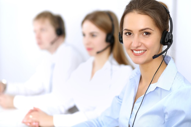 Centro de llamadas, céntrate en la hermosa mujer con auriculares.