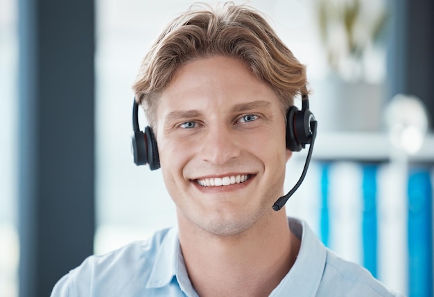 Centro de llamadas de comercio electrónico y trabajadores que trabajan consultando y brindando apoyo a las personas en línea en la empresa de telemercadeo Retrato facial de un joven empleado feliz y de servicio al cliente con una sonrisa para el servicio