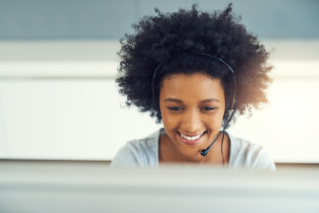Centro de llamadas computadora y consultoría con mujer afro en la oficina de soporte al cliente como asistente virtual servicio de auriculares y sonrisa con agente feliz en el lugar de trabajo para la generación de leads o ventas en línea