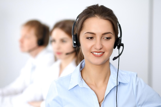 Centro de llamadas. Concéntrese en una hermosa mujer de negocios con auriculares.