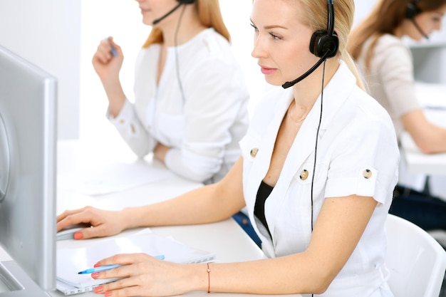 Centro de llamadas. Concéntrese en una mujer hermosa con auriculares.