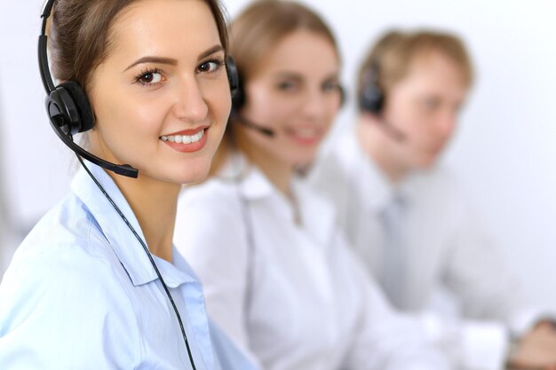 Centro de llamadas. Concéntrese en una mujer hermosa con auriculares.