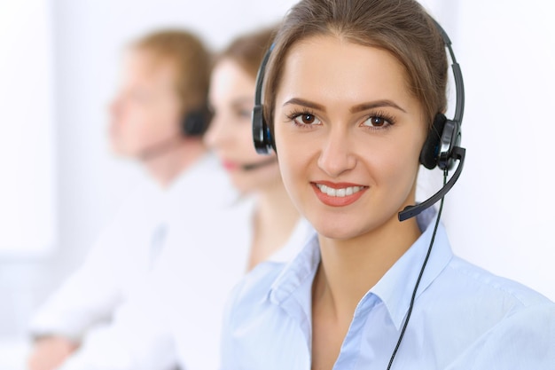 Centro de llamadas. Concéntrese en una mujer hermosa con auriculares.