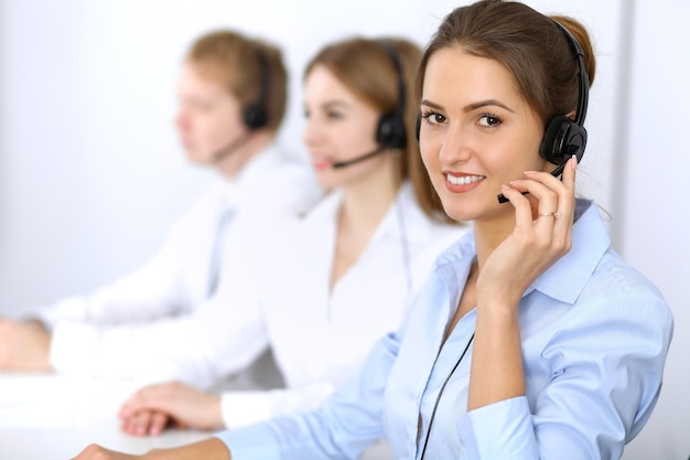 Centro de llamadas. Concéntrese en una mujer hermosa con auriculares.