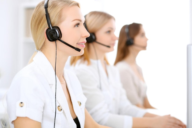 Centro de llamadas. Concéntrese en una mujer hermosa con auriculares.