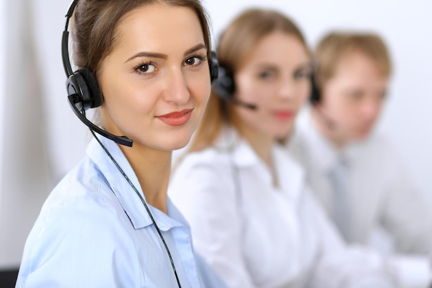 Centro de llamadas. Concéntrese en una mujer hermosa con auriculares.