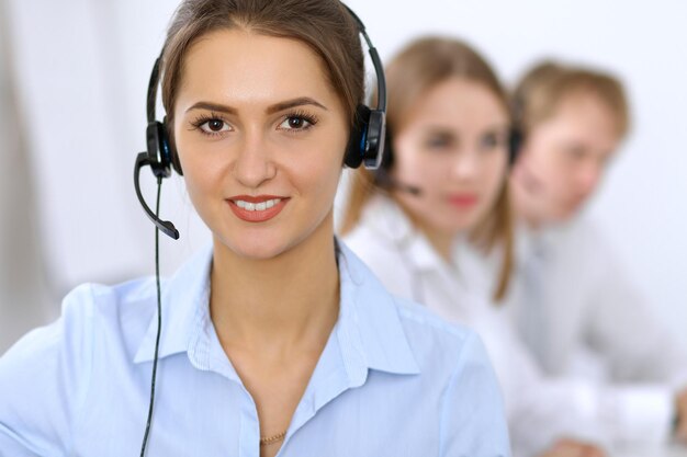 Centro de llamadas. Concéntrese en una mujer hermosa con auriculares.