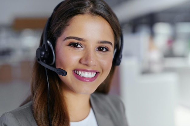 Centro de llamadas feliz y retrato con mujer en la oficina para soporte de comunicación y telemarketing auriculares de consultor y sonrisa con tecnología en el negocio para ventas entrantes servicio al cliente o comercio electrónico