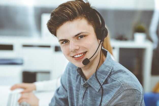 Foto centro de llamadas grupo de operadores vestidos casuales en el trabajo empresario en auriculares en la oficina de servicio al cliente televentas en el negocio