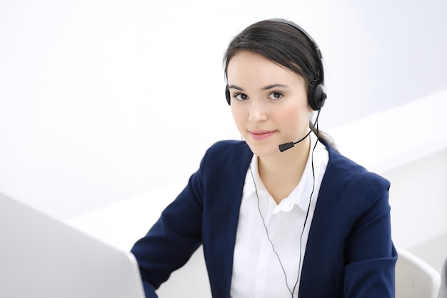 Centro de llamadas Hermosa mujer sentada y trabajando con auriculares en la oficina de servicio al cliente Concepto de negocio