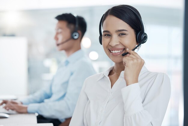 Centro de llamadas de mujer y consultora de sonrisas en el espacio de trabajo de la oficina y con auriculares para conversar con el cliente Trabajadora de telemarketing y chica trabajadora hablando de discusión o ayudando al cliente en el lugar de trabajo