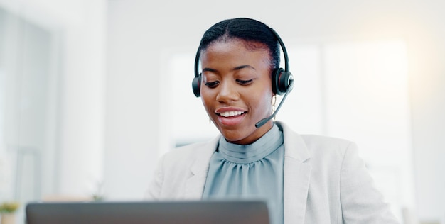 Centro de llamadas de mujeres negras y consultoría en una computadora portátil para servicio al cliente de telemercadeo o soporte de escritorio Consultora africana amigable hablando con auriculares para obtener ayuda, asesoramiento o comunicación
