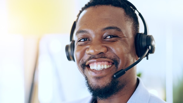 Centro de llamadas de retratos y hombre negro feliz en soporte de telemercadeo y mesa de ayuda en la oficina Agente de ventas de servicio al cliente y rostro de consultor profesional africano y sonrisa en Nigeria