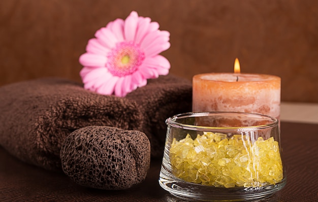 Centro de spa con toallas y flor de gerbera.