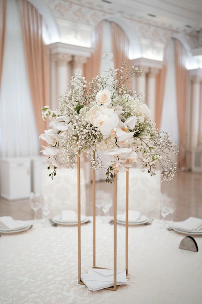 Centros de mesa de casamento, com vaso de metal e arranjos de flores brancas frescas.