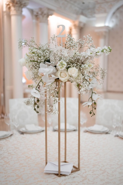 Centros de mesa para bodas, con jarrón de metal y arreglos de flores frescas blancas.