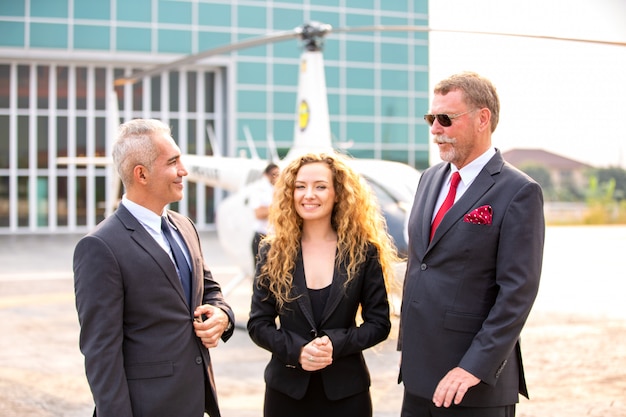 CEO ejecutivo con gafas de sol y de pie en el helicóptero
