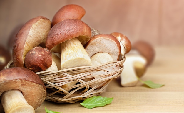 cep de champiñones porcini en una cesta sobre una mesa de madera