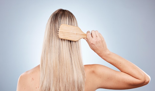 Cepillo de belleza para el cuidado del cabello y la espalda de la mujer en el estudio aislado sobre fondo gris Peluquería y modelo femenino cepillado del cabello para una rutina matutina saludable bienestar y tratamiento cosmético para el cabello