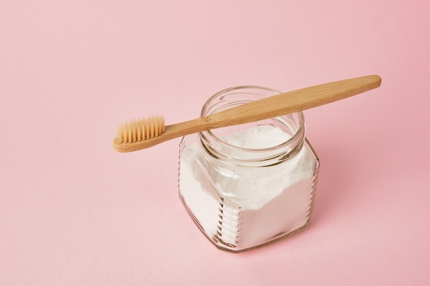 Cepillo de dientes de bambú y refrescos en tarro en el espacio de copia de fondo rosa