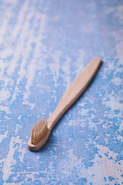 Cepillo de dientes de bambú sobre fondo de madera azul