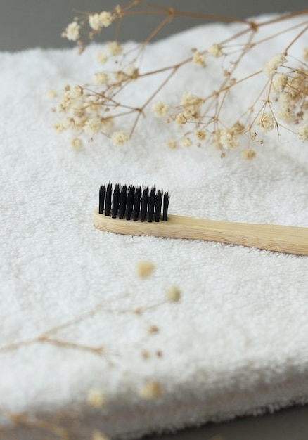 Cepillo de dientes de bambú con una toalla de algodón y flores en concepto de fondo ecológico copyspase zero waste